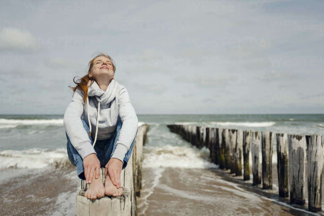 Woman sitting on fence at the beach, relaxing at the sea 11 Ejercicios para Superar el Estrés y Mejorar tu Salud Mental